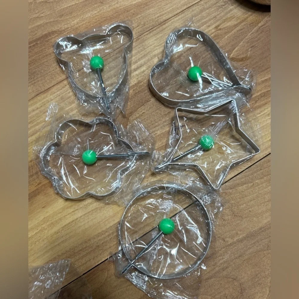 Set of 5 stainless steel Egg & Pancake Molds with Green Handles.